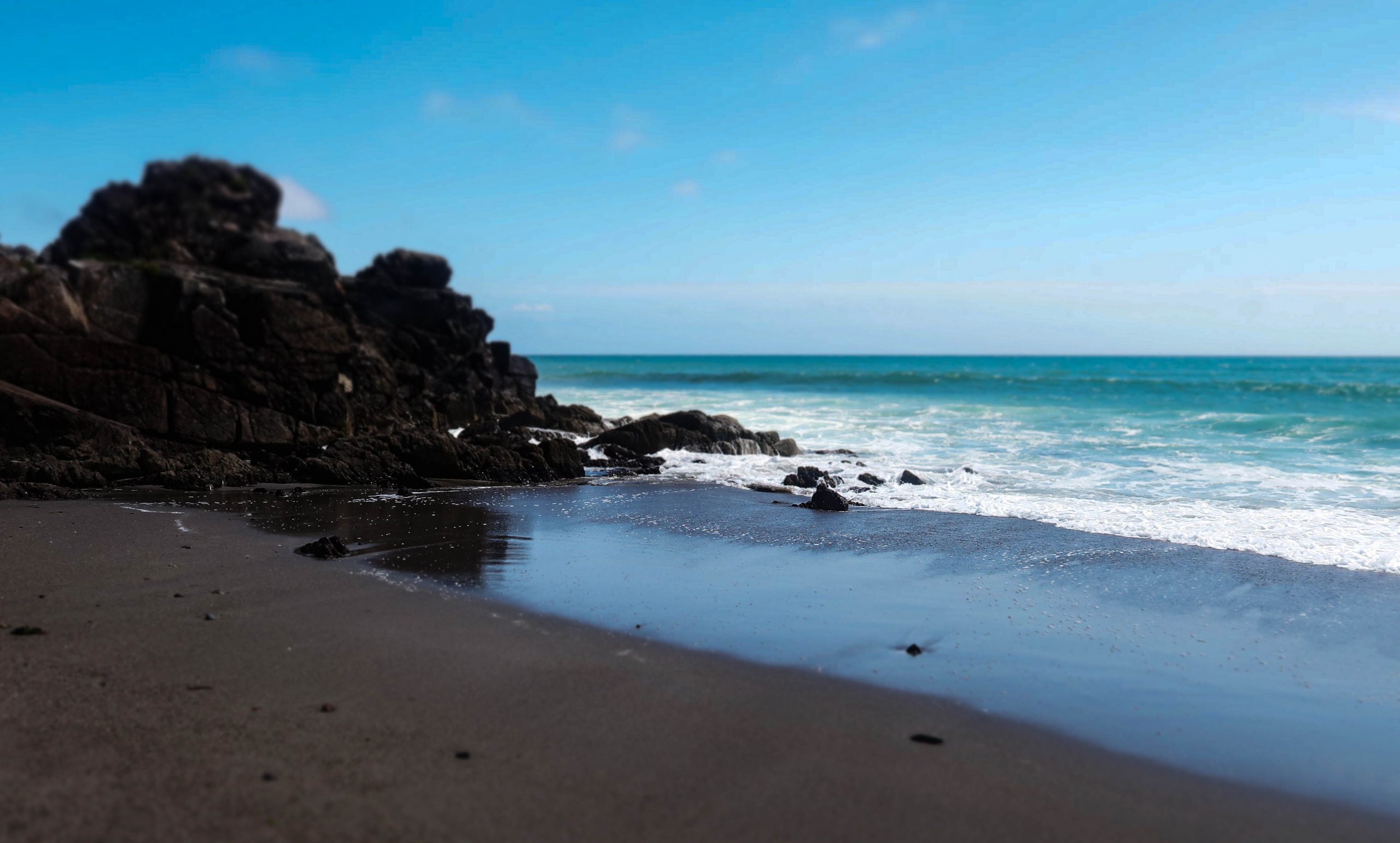Picture of pebbles on the beach with people play at the waters edge
